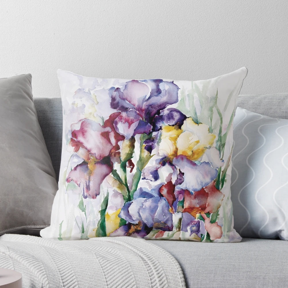 Vibrant watercolor painting of purple iris flowers on a decorative throw pillow.